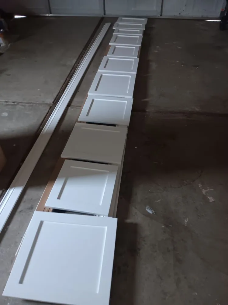 Cabinet doors laid out in a row after spraying