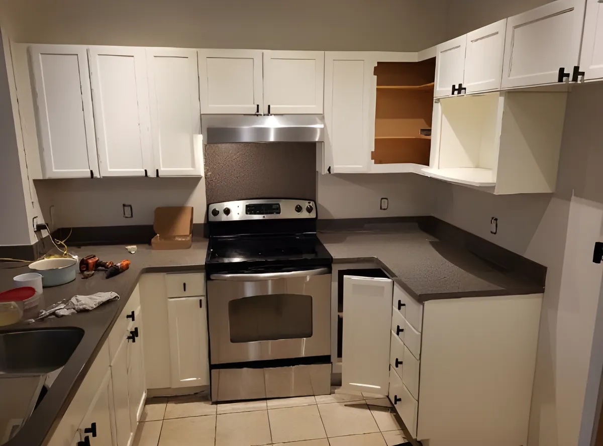 A kitchen with its cabinets painted white and new black pulls