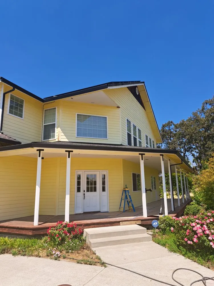 Before: a two-story house in faded yellow with white porch columns