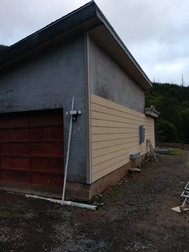 The garage part way through, new lap siding going on below the stucco